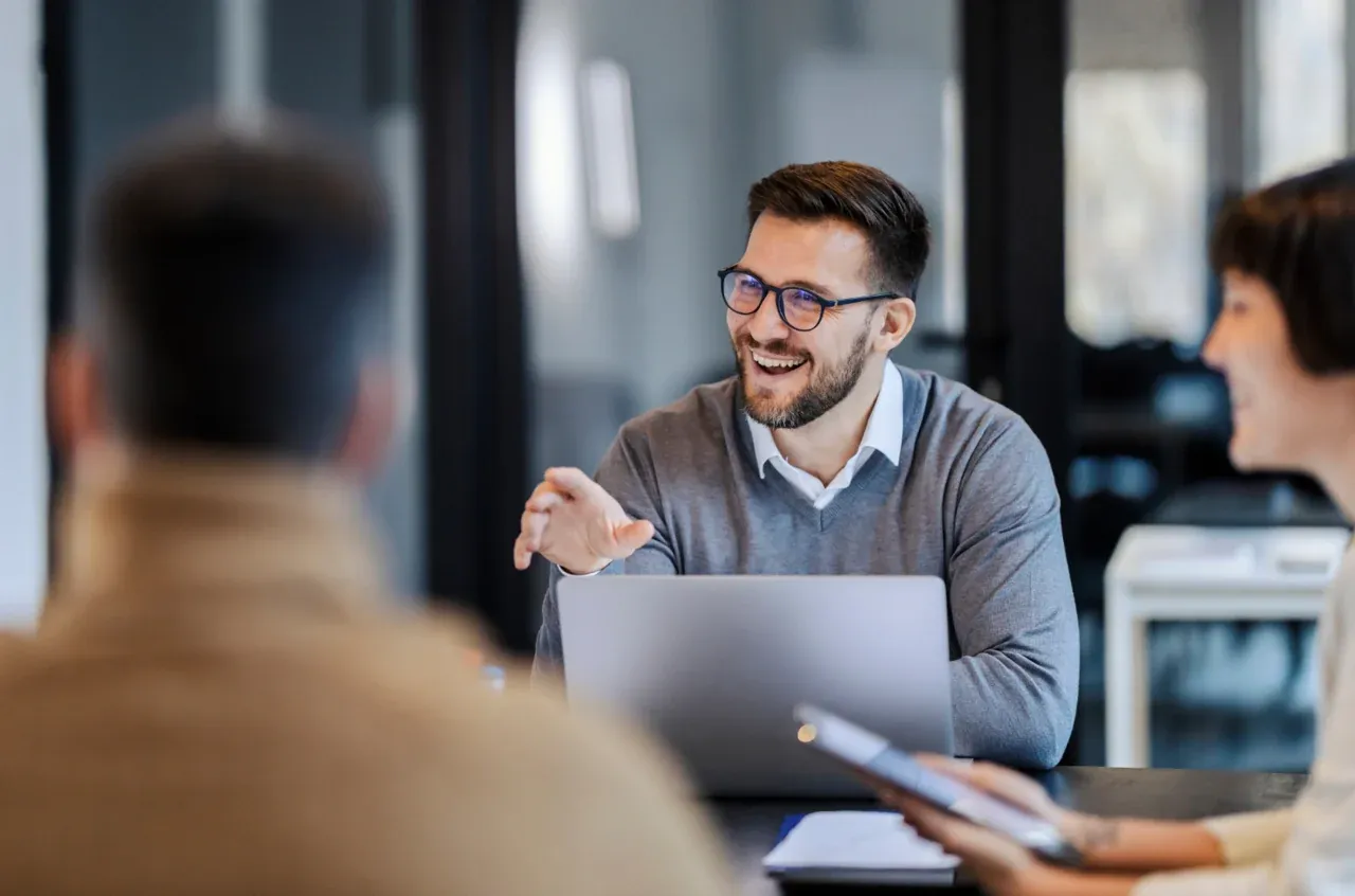 A smiling professional working at a laptop in an office